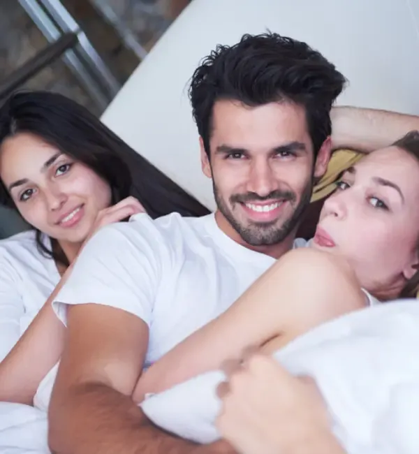 A couple with an escort lady in bed