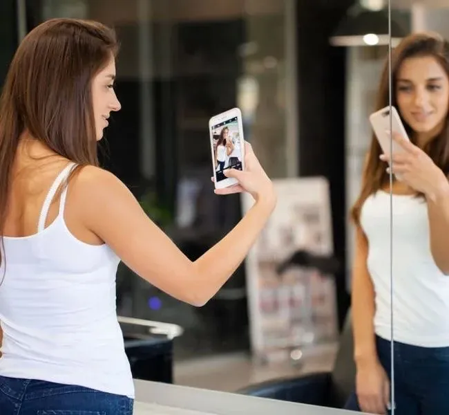 A girl taking a picture of herself for an application as an escort