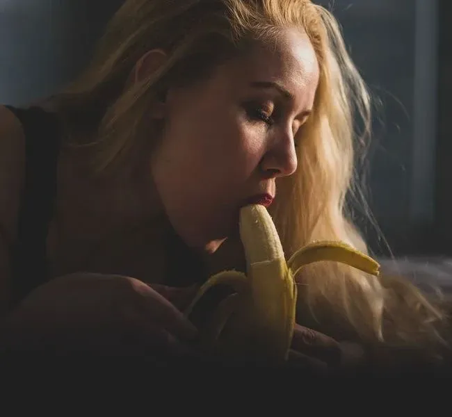 Eine Escort Dame die eine Banane bläst