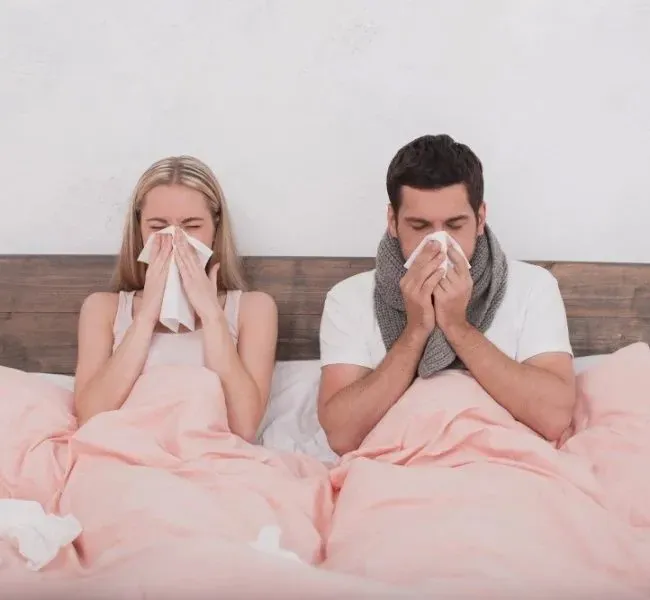 Man and woman are in bed with napkins and look sick