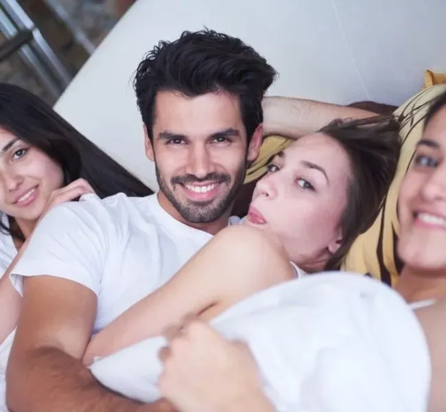 Is a man with three women in bed already group sex?