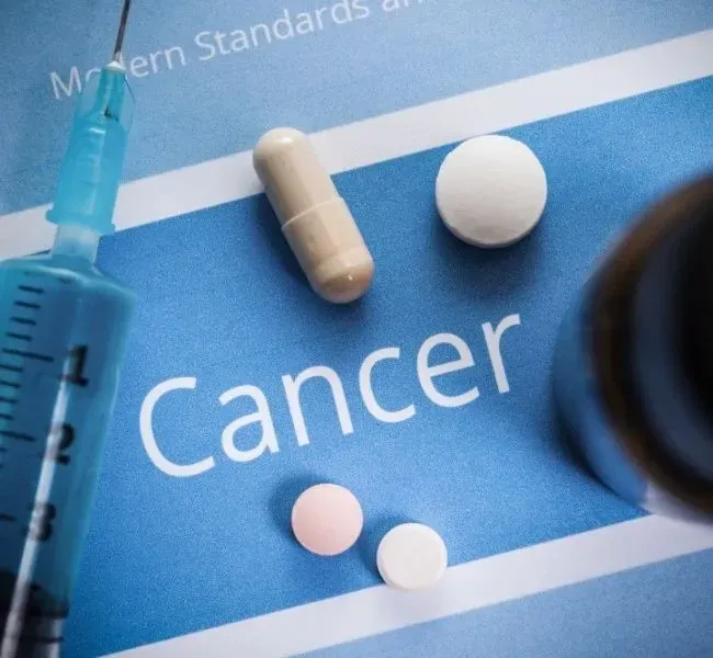 the word cancer in the middle of the picture with different pills arround