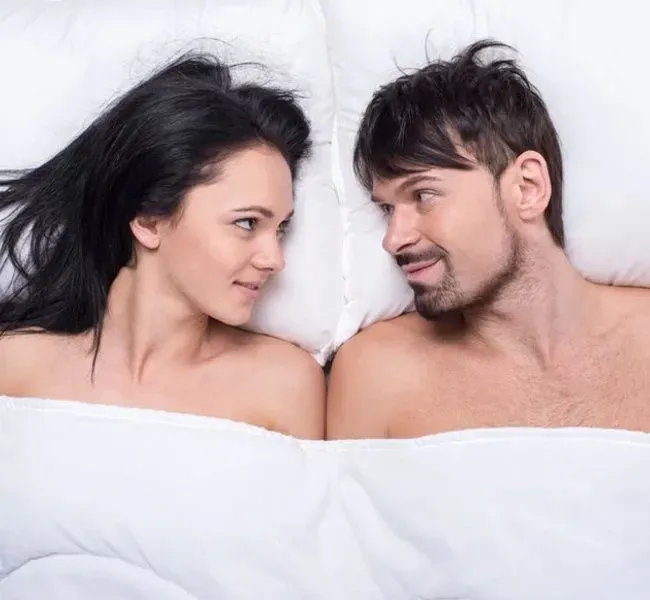 A couple in bed talking about premature ejaculation